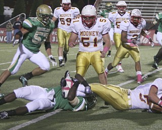 ROBERT K. YOSAY | THE VINDICATOR..Brought down behind the line  Mooney #5   Kevin McGuire QB is caught behind the line by #1  Trevor Smith - Ursuline vs Mooney at YSU stadium ...  --30-..