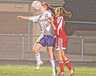 (20) Megan Harkins of Champion gets a face full of ball as (13) Andrea Ryhal plays defense during their game Monday night.