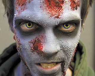 Josh Hamilton, of Salem, in preparation for his zombie character who weilds a chainsaw at the Canfield Scaregrounds on Thursday evening.