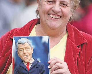 Sue Watson of Rogers shows off her dancing-and-singing Bill Clinton doll as she waits outside the Mahoning County Democratic Party headquarters in Youngstown for free tickets to a Saturday breakfast gathering with the former president.