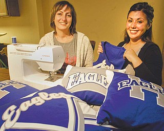 Sharon Sikora, left, mother of Alyssa Sikora, a Hubbard High School cheerleader, and Stephanie Barca, Hubbard head cheerleading coach, show off pillows fashioned from old cheerleading uniforms. Barca said she got the idea from a similar project done years ago. Sikora is using her sewing skills to make the pillows that are being sold as a fundraiser.