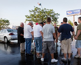 Geoffrey Hauschild|The Vindicator.6.18.2010.Members of OVTC pray in the parking lot during a carwash and crane fundraiser along U.S. 224 in Boardman.