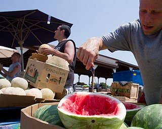 Geoffrey Hauschild|The Vindicator.7.7.2010.OVTC Intern Greg Todd cuts samples of watermelon for patrons as part of a work crew selling produce for Abraham King Produce at the Four Seasons Flea Market along 422 east of Youngstown.