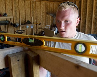 Geoffrey Hauschild|The Vindicator.8.5.2010.Anthony Sanders works on making a shelf in Pastor Bob Pavlich's garage after receiving a donation of landscaping equipment. A donation of six snowblowers, seven weedeaters, one generator and two pressure washers was made to the center.