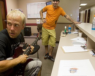 Geoffrey Hauschild|The Vindicator.8.5.2010.OVTC Intern Greg Todd plays guitar alongside intern Sean Wilson at the main desk in the residential wing of the center.