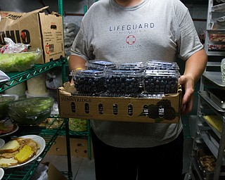 Geoffrey Hauschild|The Vindicator.8.5.2010.OVTC resident Brian Druschel gathers food from the walk-in cooler for an upcoming catering event.