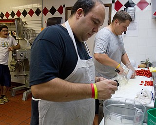 Geoffrey Hauschild|The Vindicator.8.5.2010.OVTC residents Michael Pinkerman, Steve Petracci and Brian Druschel work to complete food for an upcoming catering event while working in the Hope kitchen at OVTC.