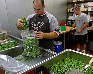 Geoffrey Hauschild|The Vindicator.8.5.2010.OVTC intern ,John Jones and resident Kevin McCoy work to package beans for freezing while in the OVTC's Hope Kitchen. The beans were donated from a local farmer.
