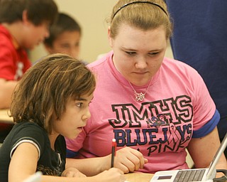 ROBERT K. YOSAY | THE VINDICATOR..Ninth graders at Jackson Milton High School taught fourth graders an interactive poetry lesson during a reading of The Raven by Edgar Allan Poe..Breanna Saunders ( pink shirt ) 9th grade - asks questions of Lindsey Osborne 4th grade -- to help her understand the poem .. --30-.
