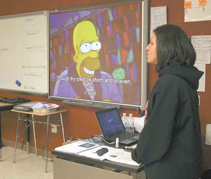 At left, ninth-grade teacher Rochelle Morelli makes comments to her class during a video clip from an episode of “The Simpsons,” which featured a reading of Edgar Allan Poe’s “The Raven.” Morelli’s students used high-tech learning tools to teach the fourth-graders about Edgar Allan Poe and his classic poem. Morelli’s class is studying Gothic literature.
