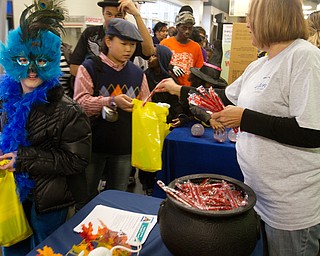 Geoffrey Hauschild|The Vindicator.Boardman residents, Haley Nick, 10, dresses as a Peacock, while Jacinta Pikunas, 11, sports a golfers wardrobe while receiving candy from Elaine Vrancich, who manned a booth for Unison By United Health Care at the Covelli Centre on Saturday evening.