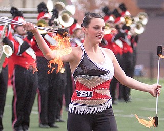 Geoffrey Hauschild|The Vindicator .YSU freshman, Rosie Bird, twirls flaming batons while performing during the football halftime show at YSU's Stambaugh Stadium on Saturday afternooon.