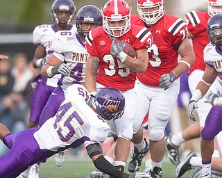 Geoffrey Hauschild|The Vindicator .YSU's Jamaine Cook (35) runs over Iowa's Jamar Thompson (45) and others on his way toward scoring a Penguins touchdown during the fourth quarter at Stambaugh Stadium.