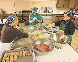 Members of Mahoning United Methodist Church, from left, Hallewell, Cindy Kramer and Dawn Crosby form a production line to make halupki. The crew makes between 200 and 400 cabbage rolls weekly. TheyÕre hoping people on the go on Election Day stop and buy some for dinner. .