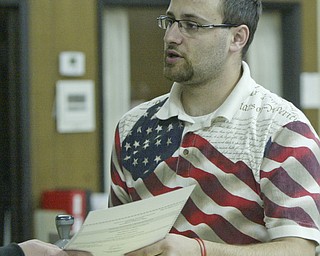 William D Lewis The Vindicator Trumbull Bd of elections worker Nicholas Jordan hands a ballot to a provisional voter at the TRumbull BOE shortly before polls closed Tuesday.