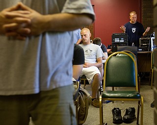 Geoffrey Hauschild.6.7.2010.Greg Todd (right) prays while playing Christian-themed rock and country music during a daily chapel service at OVTC. Austin Henderson sits at center while other residents move about praying and reading from the bible. Praying while kneeing is no longer allowed as some residents used the opportunity to rest their head on the chair and nap.