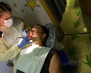 Geoffrey Hauschild|The Vindicator.6.7.2010. Josh Pasture receives a free teeth cleaning from dental hygenist Christy Zedaker of Poland, on board the Mobile Dental Van, a traveling dental service operated by Humility of Mary Health Partners, during one of its regular visits to OVTC. The van most commonly treats Youngstown and Warren city school students, however, residents' appointments are covered through the Health Care Assurance Program.