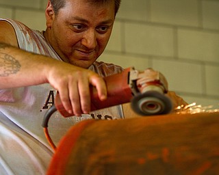 Geoffrey Hauschild|The VIndicator.6.15.2010.While working at the Canfield Fairgrounds, John Anderson sands down a piece of equipment to be repainted.