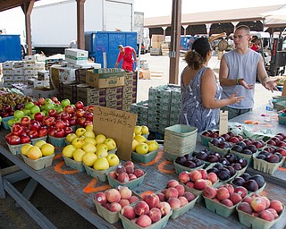 Geoffrey Hauschild|The Vindicator.7.7.2010.OVTC student, Dennis McKenney (right) sells produce for Abraham King Produce at the Four Seasons Flea Market along 422 east of Youngstown.