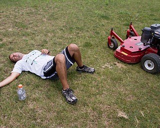 Geoffrey Hauschild|The Vindicator.7.26.2010.OVTC resident Scott Fabry takes a break alongside a piece of landscaping equipment while working at Arlington Heights.