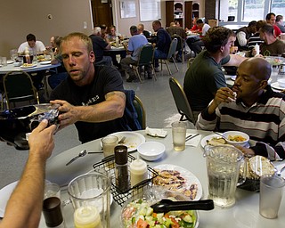 Geoffrey Hauschild|The Vindicator.9.21.2010.Intern Greg Todd passes a bowl of pasta while sitting next to staff member Phillip Bobo during dinner at OVTC.