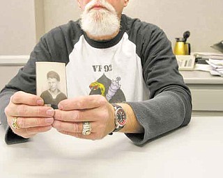 William D. Green, a Vietnam War Navy veteran, holds a picture of his father, Desmond C. Green, who served in the Navy during World War II. In front of Green are the decorations he won as a crew member of the aircraft carrier USS Constellation. Among them is the Presidential Meritorious Unit Citation.