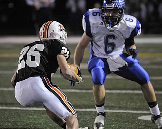 Chargin Falls Billy Cale, 26, slips pasr Michael Prindle, 6, during their game at Arura on friday night. Photo/Mark Stahl