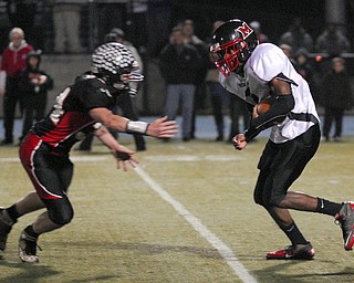 Campbell's Lester Hughes runs the ball against Manchester's Mark Noble on Friday night at Ravenna High School.