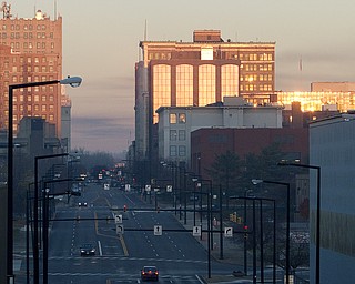 The sunrise reflects off buildings from the East side of Youngstown on Friday morning. (Geoffrey Hauschild | The Vindicator)