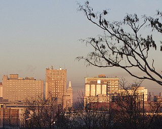The sunrise reflects off buildings from the East side of Youngstown on Friday morning. (Geoffrey Hauschild | The Vindicator)