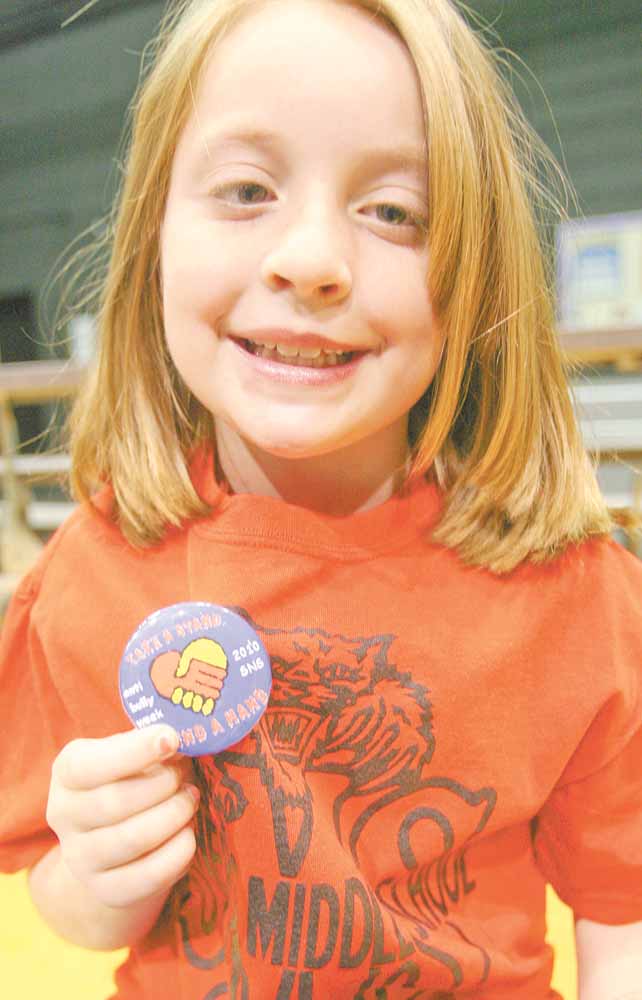 Anti Bully assembly at Struthers Middle School - Mariah Mas  5th grader shows off the buttons each student received from the catholc school to share against bullying . 