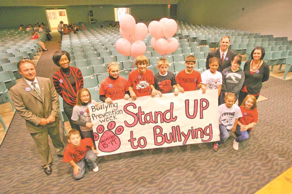 Struthers Middle School kicked off Bullying Prevention Week at an assembly Monday morning. From left are Struthers Mayor Terry Stocker and guidance counselor Kendra Broome. Kneeling is fifth-grader Jacob Dankovich. Clockwise around the sign are sixth-grader Jenna Farkas, sixth-grader Brianna Ostrowski, eighth-grader Matthew Bollinger, eighth-grader Ryan Kern, sixth-grader John Medvec, eighth-grader Nigeria Morgan, fifth-grader Channon Adriana Wuattro and fifth-grader Mariah Mass. Behind them is school principal Peter Pirone and Yvonne Wilson, juvenile diversion officer.
