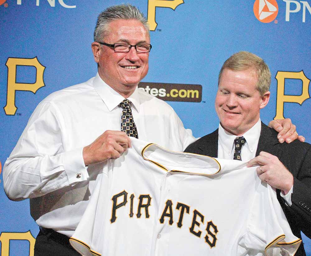 Pittsburgh Pirates new manager Clint Hurdle, left, is presented a Pirates jersey by Pirates general manager Neil Huntington after being introduced as the 39th manager in the history of the Pittsburgh Pirates, Monday, Nov. 15, 2010. (AP Photo/Gene J. Puskar)