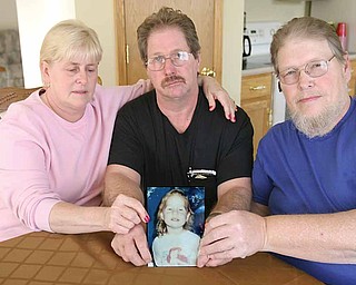 Family members of Jessica Ballew hold a portrait of her. They are, from left, Connie Ressler, Jessica’s aunt; Virgil Ballew, her father; and Steve Ballew, her uncle. Gov. Ted Strickland’s clemency to the killer of Jessica has angered the family.
