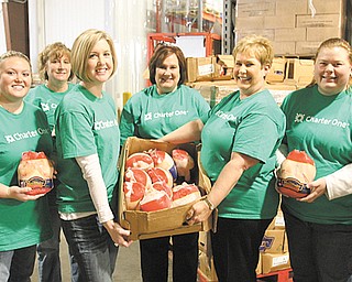 Several Charter One volunteers at the food bank warehouse on Salt Springs Road, Youngstown, display some of the 3,012 chickens donated by the Charter One Foundation. From left are Jim Basista, Jenna Howard, Casey Martin, Amy Manolio , Judy Larson, Diana Hogg, Kim Williams and Becky Greenwood. Second Harvest received a $10,000 grant from the Charter One Foundation.