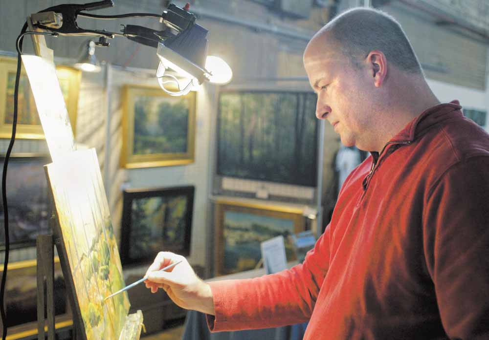 Canfield artist Chris Leeper works on a painting during annual Holiday  Open studio and Art Sale  in the Ward Bakery Building Sunday. 