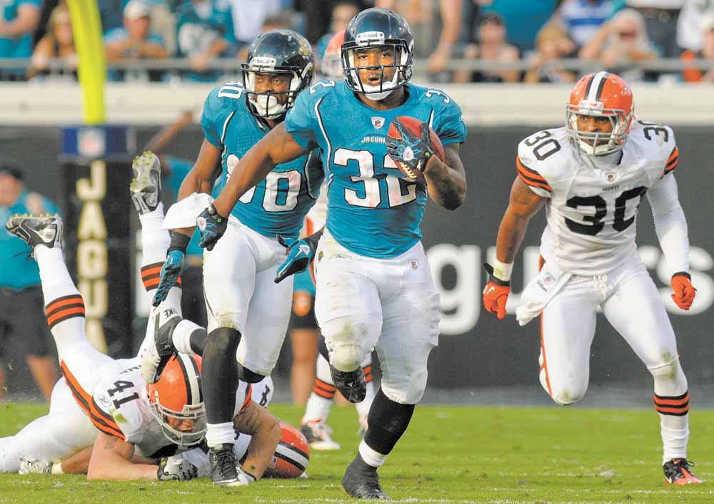 Jacksonville Jaguars running back Maurice Jones-Drew (32), center, breaks free from Cleveland Browns cornerback Raymond Ventrone (41), left, and Eric King (30) for a 75-yard run during the second half of an NFL football game in Jacksonville, Fla., Sunday, Nov. 21, 2010. The Jaguars won 24-20. (AP Photo/Phelan M. Ebenhack)