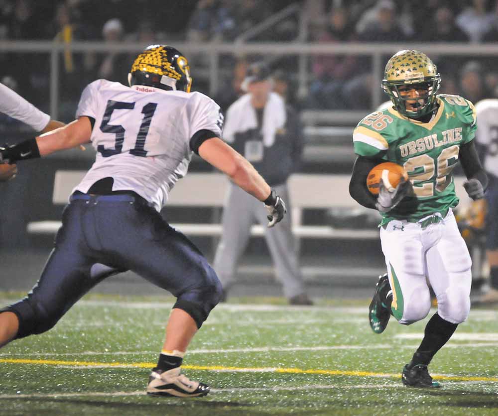 Ursuline's Akise Teague runs the ball against Kirtland during the first half of their game in Auora on Saturday night. 