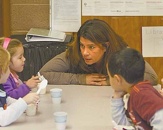 Michelle Frease, director of St. Rose Sunny Days Child Care Center in Girard, talks with students ages 3 to 4 during snack time. Sunny Days has zero state licensing violations, a record Frease attributes to low classroom ratios and a diligent teaching staff.
