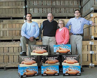 Vick Family Farms in Wilson, N.C. From left: Dwayne Ferrell, packing house manager, owner Jerome Vick and his wife Diane, and food safety manager Shea Leatherman pose in front of crates full of sweet potatoes.