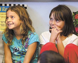 Courtney Mercer and Madison Kish, third-graders at Lloyd Elementary in Austintown, listen intently during Stacey Lundgren’s Bucketfilling presentation. At the end of her presentation, Lundgren left a plastic bucket for each classroom.
