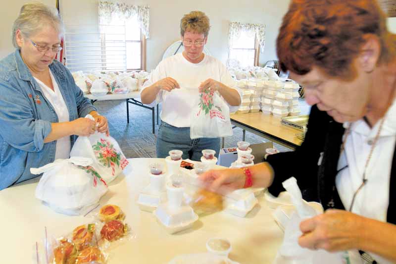 Civil deputies with the Mahoning County Sheriff’s Department Senior Services assemble Thanksgiving dinners for seniors Wednesday at First Federated Church of North Jackson. From left are Diane Bates of Youngstown, Michele Nutt of Austintown and Carol Avery of Ellsworth.