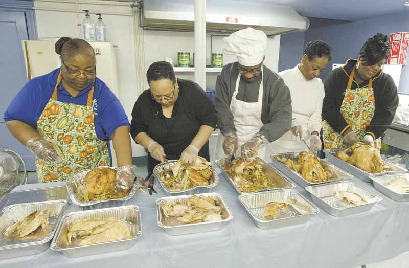 Members of Christian Revival and Discipleship Center carve turkey dinner to be distributed to Youngstown  police working on Thanksgiving. From left, they are Brennetta Stephens, Phyllis Jackson, Christopher McKee, Pat Fordham and Michelle White.