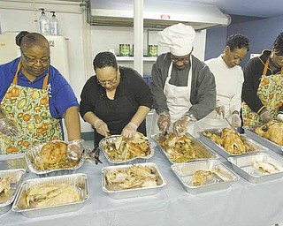 Members of Christian Revival and Discipleship Center carve turkey dinner to be distributed to Youngstown  police working on Thanksgiving. From left, they are Brennetta Stephens, Phyllis Jackson, Christopher McKee, Pat Fordham and Michelle White.