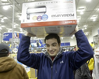 William D. Lewis|The Vindicator A large crowd qued up outside the Boardman Best Buy at 5am Friday to get Black Friday bargins. Nick Mancini of Canfield carries a printer to the check out line.