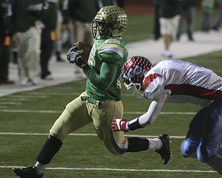 FOOTBALL - Akise Teague flies past Rufus Johnson for yards Saturday night in Ashland. - Special to The Vindicator/Nick Mays