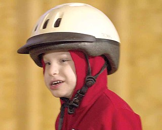 Cody Denmeade, 4, smiles during a therapeutic riding session at the Forget Me Not Horse Farm. Jenessa Spangler, 9, of Cortland, has been fundraising to help Cody attend the sessions, which cost $20 for a half hour.