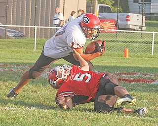 Eric Ahmer (5) makes a one handed tackle of Landon Smith Friday night in Struthers. 