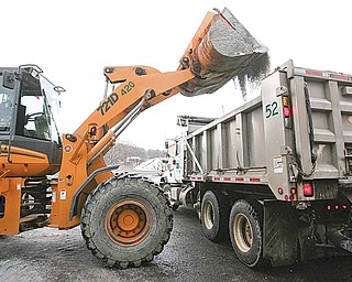 Workers move road salt from a bin to a truck at the Mahoning County Engineer’s Office on Industrial Road.
