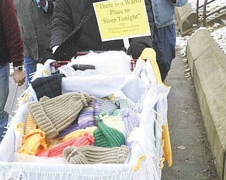 Participants in the third annual Homeless Walk make their way along Martin Luther King Jr. Boulevard in Youngstown. Cindy Pickens from Help Hotline Crisis Center pushed a shopping cart filled with knitted mittens and hats.
